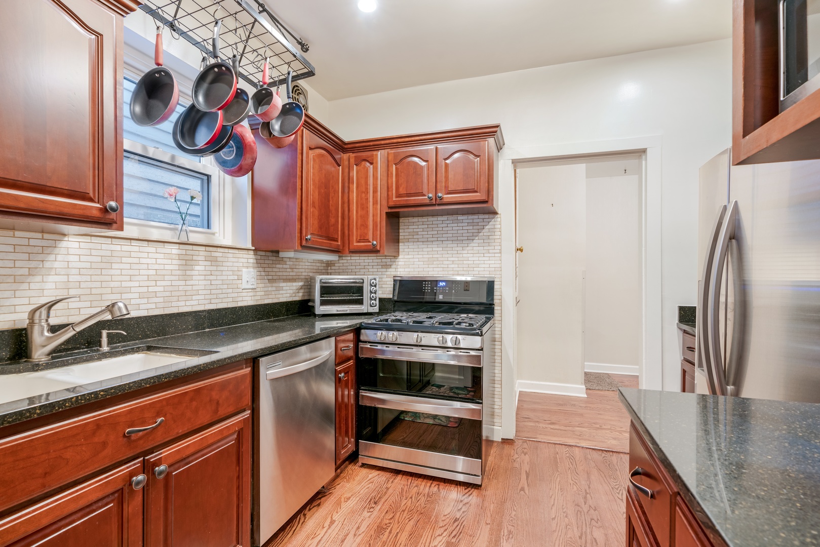 5474 South Ridgewood Court Chicago, IL 60615 - Photo 5 of 14 a kitchen with stainless steel appliances granite countertop a stove top oven a sink and dishwasher