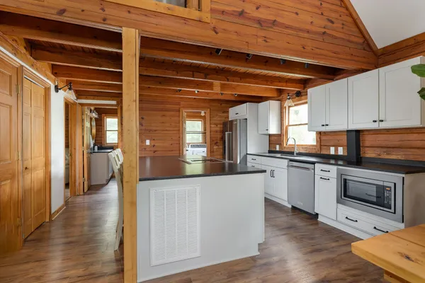 a kitchen with stainless steel appliances granite countertop a sink a stove and a wooden floors
