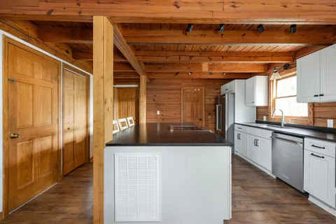 a kitchen with table chairs stainless steel appliances and cabinets