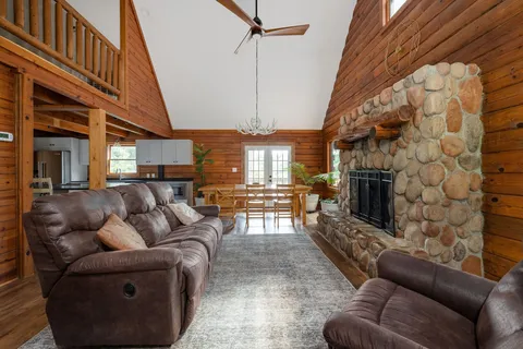 a living room with furniture a fireplace and potted plants