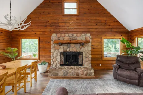 a living room with furniture a fireplace and a floor to ceiling window