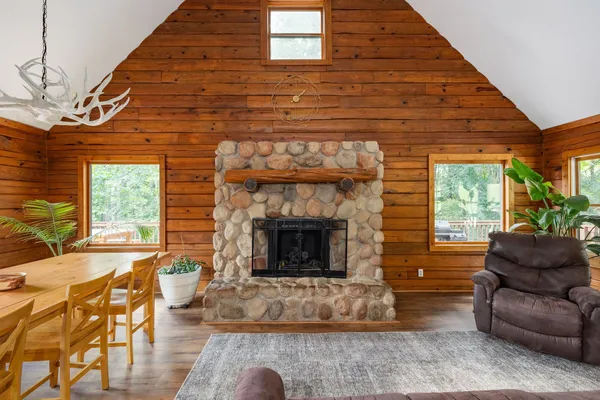 a living room with furniture a fireplace and a floor to ceiling window