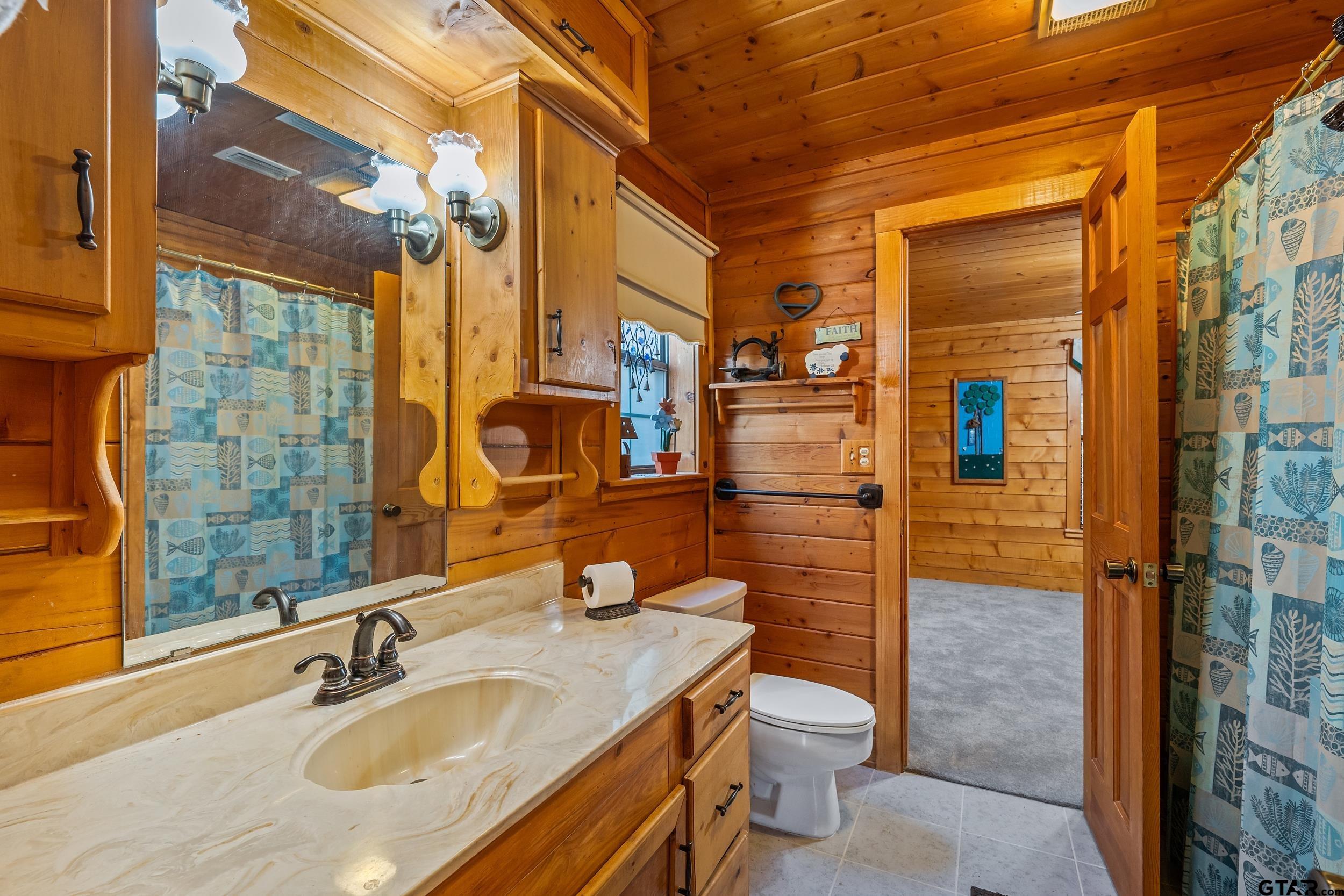 325 Laurel Lane Holly Lake Ranch, TX 75765 - Photo 16 of 34 a bathroom with a granite countertop sink toilet and shower