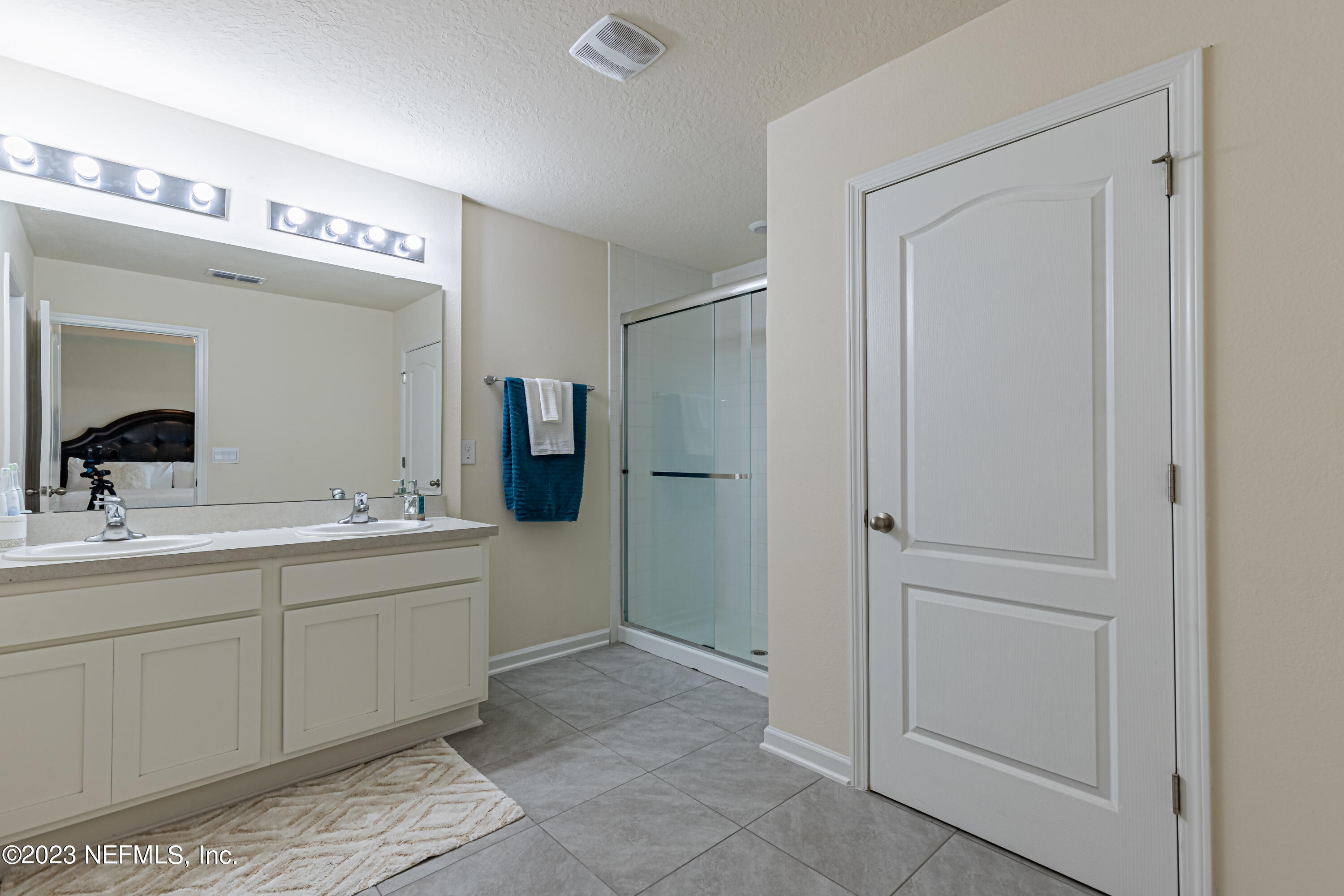 86205 Mainline Road Yulee, FL 32097 - Photo 11 of 19 a spacious bathroom with a mirror a sink and a shower