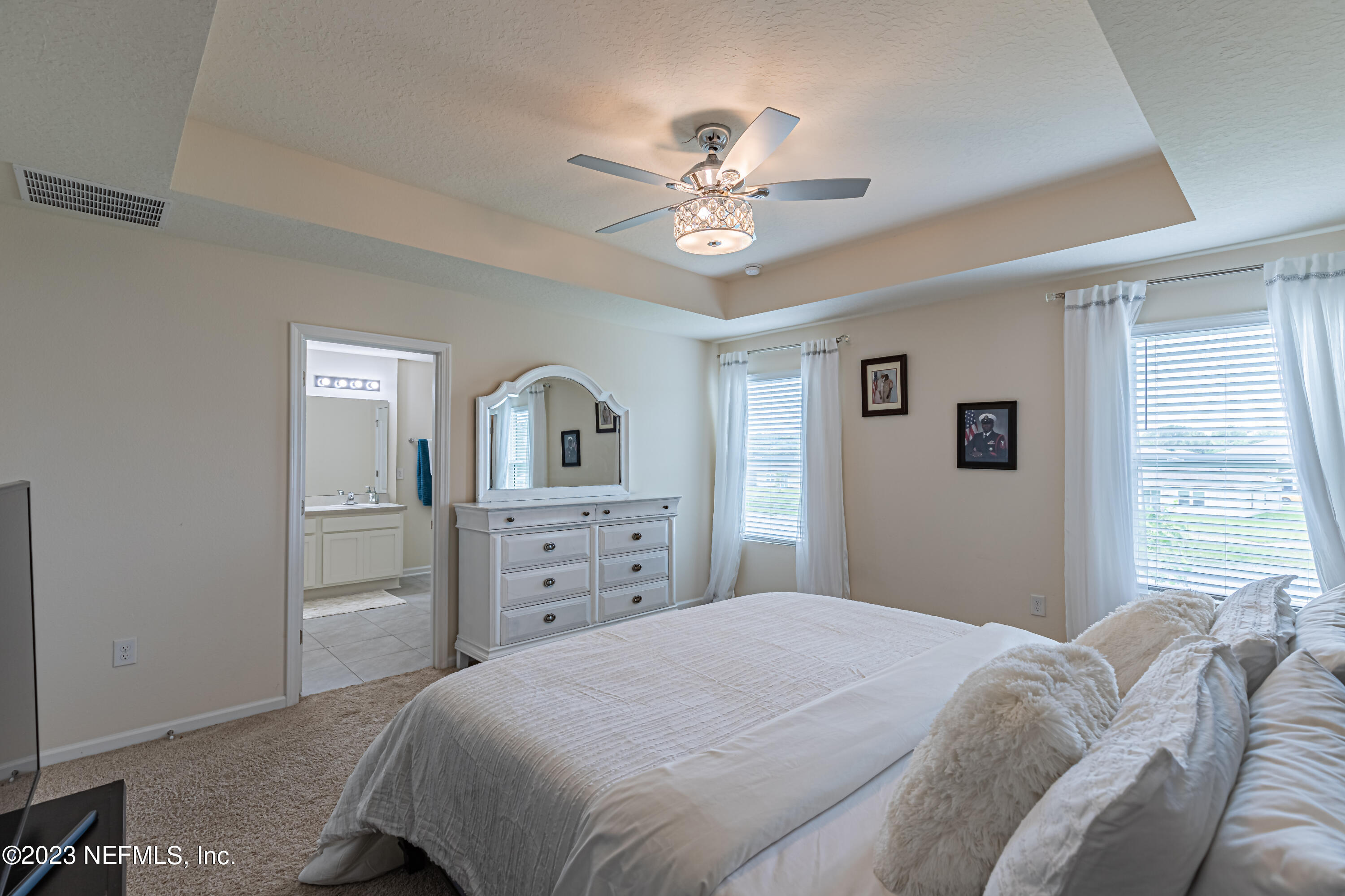 86205 Mainline Road Yulee, FL 32097 - Photo 10 of 19 a bedroom with a bed and a chandelier