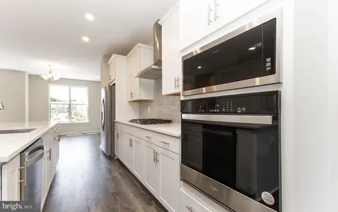 a kitchen with stainless steel appliances granite countertop a stove and a microwave