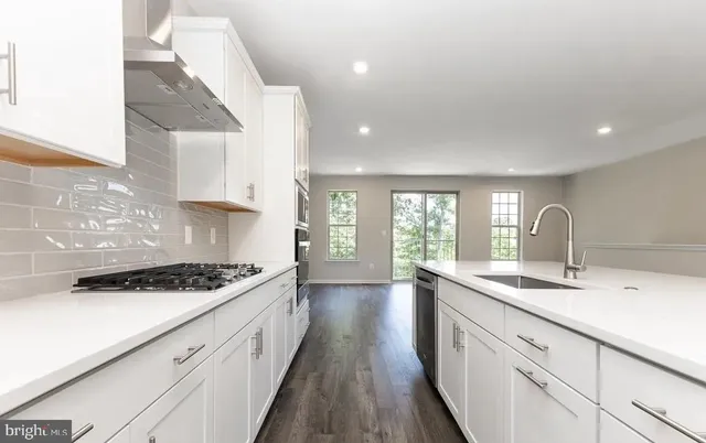 a kitchen with sink a stove and cabinets