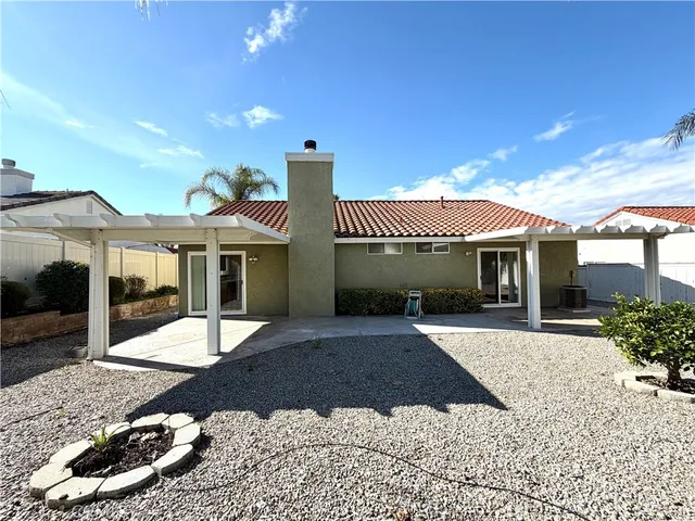 a view of a house with a patio and a yard