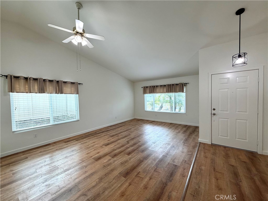 44836 Marge Place Temecula, CA 92592 - Photo 6 of 35 an empty room with wooden floor chandelier fan and windows