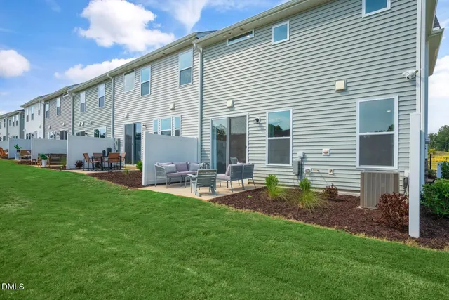a view of a house with a backyard and sitting area
