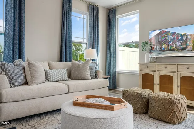 a living room with furniture a fireplace and a large window
