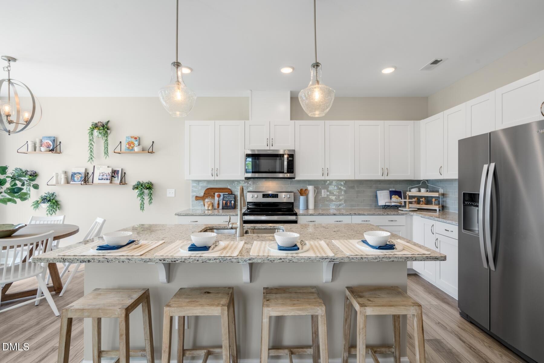 167 Siebold Street Garner, NC 27529 - Photo 26 of 42 a kitchen with a dining table chairs refrigerator and microwave