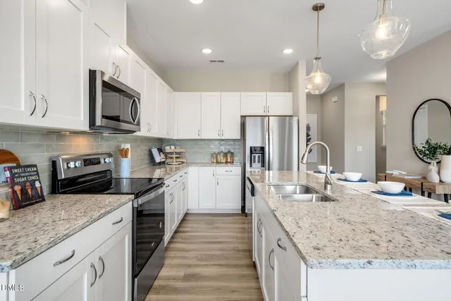 a kitchen with stainless steel appliances granite countertop a sink stove and refrigerator