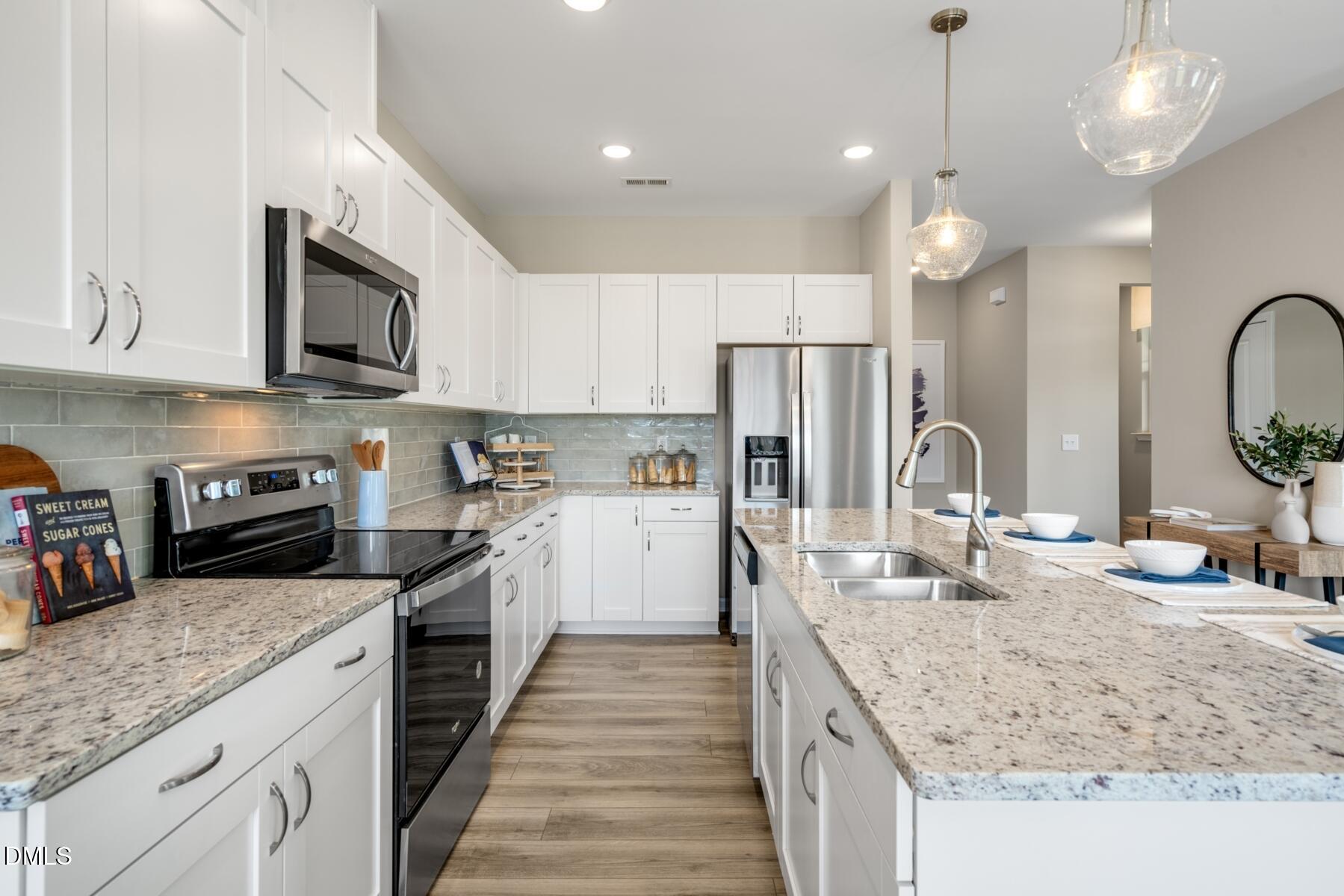167 Siebold Street Garner, NC 27529 - Photo 31 of 46 a kitchen with stainless steel appliances granite countertop a sink stove and refrigerator