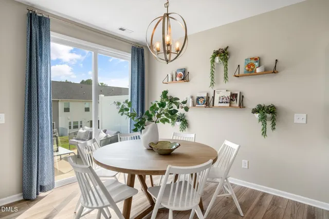 a dining room with furniture potted plants and wooden floor