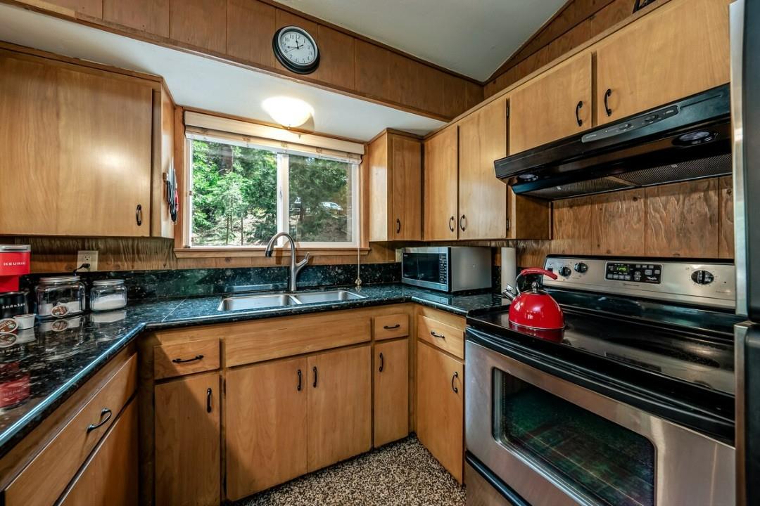 42318 Hanging Branch Road Shaver Lake, CA 93664 - Photo 6 of 13 a kitchen with stainless steel appliances a stove a sink and a microwave