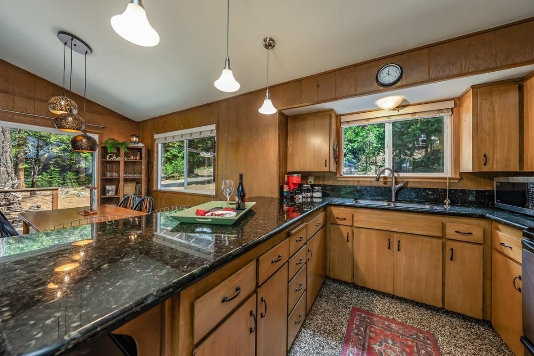 42318 Hanging Branch Road Shaver Lake, CA 93664 - Photo 7 of 13 a kitchen with large windows and chandelier