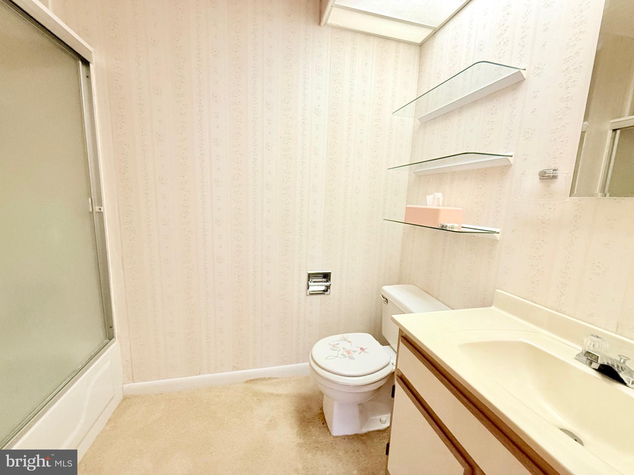 48724 Curleys Road Ridge, MD 20680 - Photo 24 of 44 a white toilet sitting next to a bathroom sink and vanity