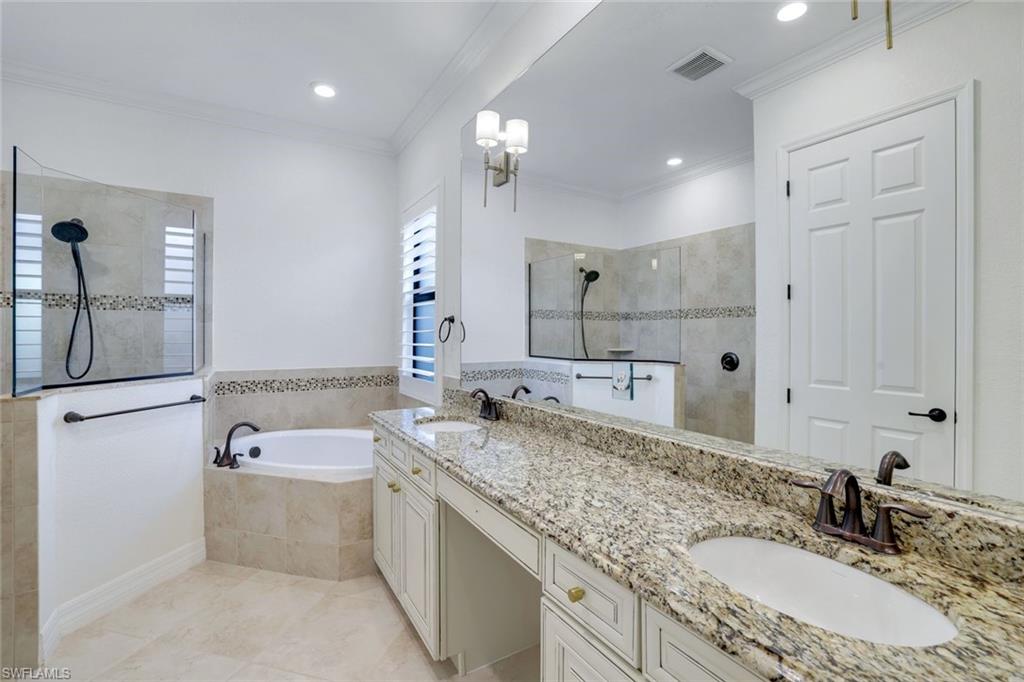 2806 Aviamar Circle Naples, FL 34114 - Photo 16 of 50 a bathroom with a granite countertop double vanity sink a mirror and a bathtub