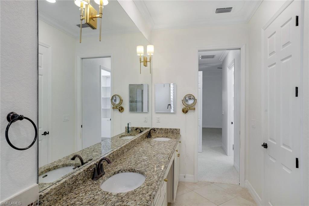 2806 Aviamar Circle Naples, FL 34114 - Photo 20 of 50 a bathroom with a granite countertop sink and a mirror