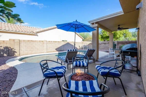 a view of a chair and table in backyard of the house