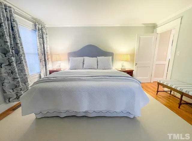 a dining room with wooden floor a chandelier a wooden table and chairs