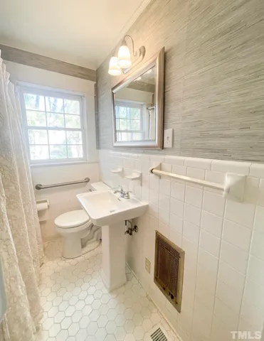 a dining room with wooden floor a chandelier a wooden table and chairs