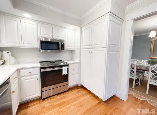 a large kitchen with kitchen island wooden cabinets and stainless steel appliances