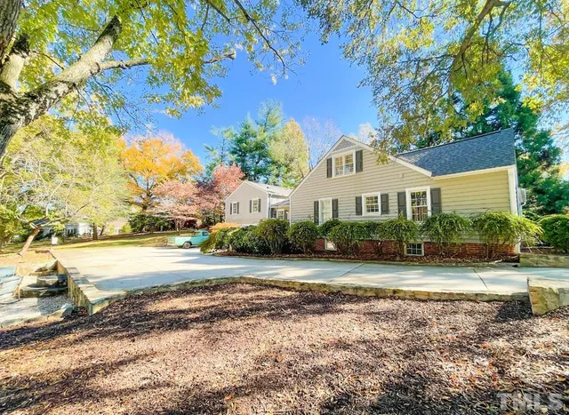 a front view of a house with a yard and lake view