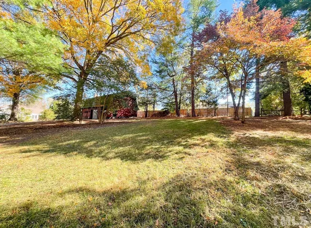 a view of a house with a yard and tree s