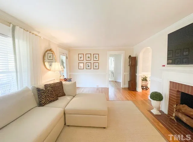 a living room with furniture a fireplace and a flat screen tv