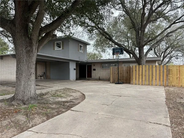 a view of a house with a tree in front of it