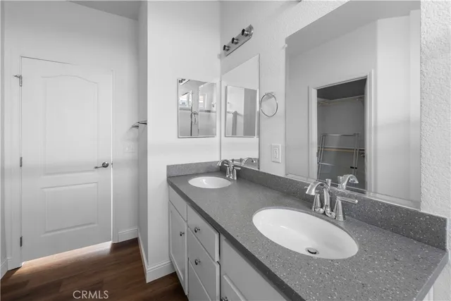 a bathroom with a granite countertop double vanity sink and mirror