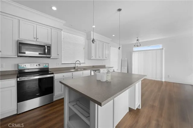 a kitchen with kitchen island granite countertop a sink and microwave