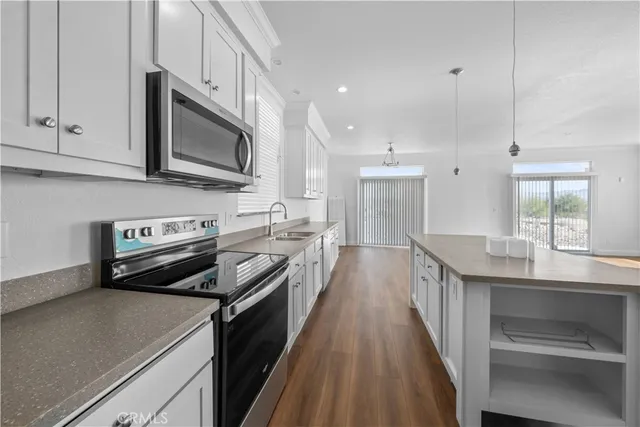 a kitchen with stainless steel appliances a stove microwave and sink
