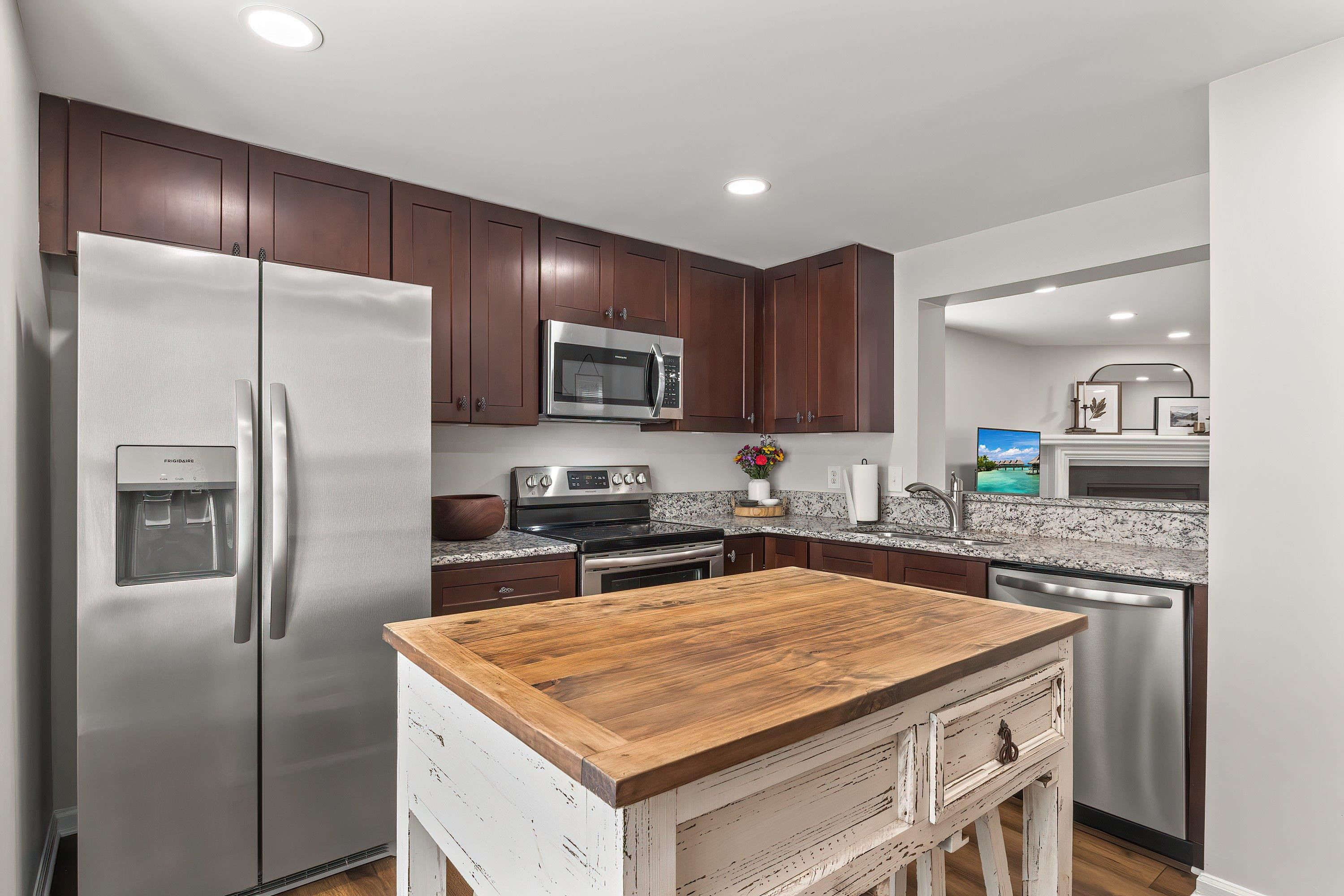 7286 Shellburne Drive Raleigh, NC 27612 - Photo 5 of 35 a kitchen with stainless steel appliances granite countertop a refrigerator a stove and a sink with wooden floor