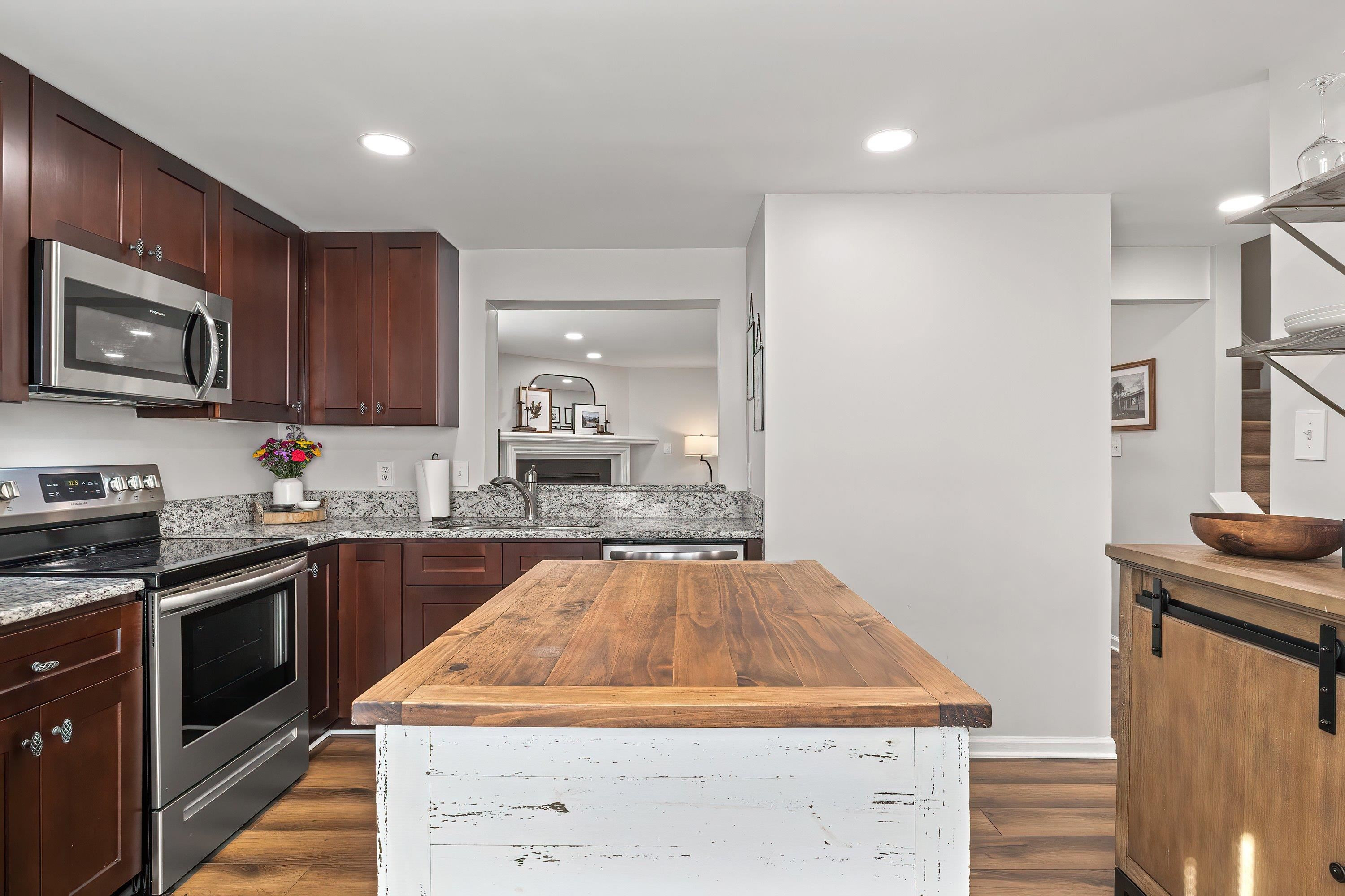 7286 Shellburne Drive Raleigh, NC 27612 - Photo 6 of 35 a kitchen with stainless steel appliances granite countertop wooden cabinets stove top oven and sink