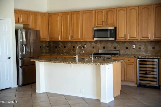 a kitchen with stainless steel appliances granite countertop a stove a refrigerator and a microwave