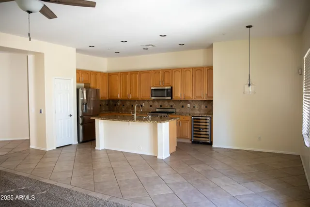 a kitchen with a refrigerator and white cabinets