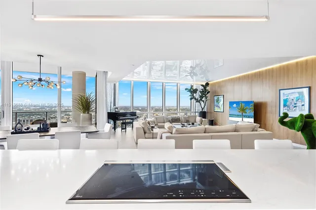 a large white kitchen with a large window and furniture