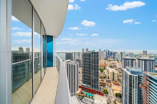 a bedroom with a large bed and a large window with balcony view