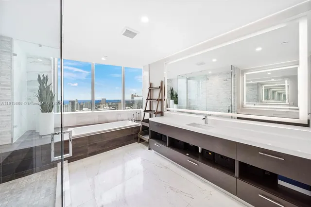 a spacious bathroom with a double vanity sink a large mirror and shower