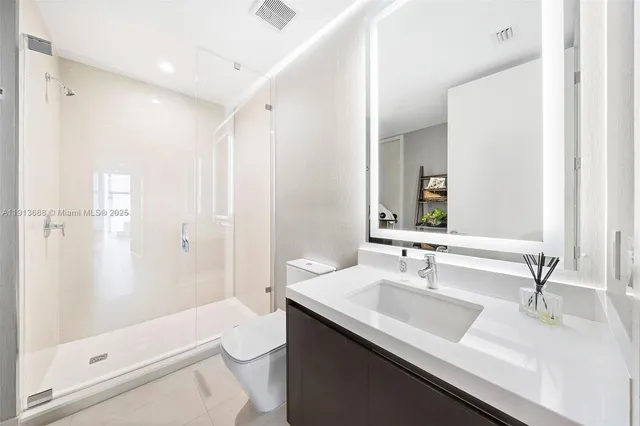 a bedroom with a large bed and a potted plant