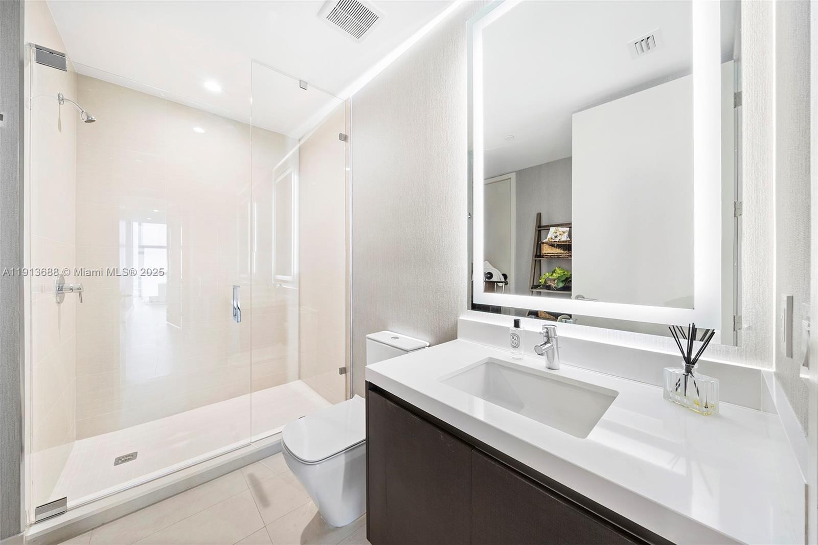 851 Northeast 1st Avenue, Unit 5312 Miami, FL 33132 - Photo 34 of 53 a bathroom with a sink a toilet a shower and a mirror