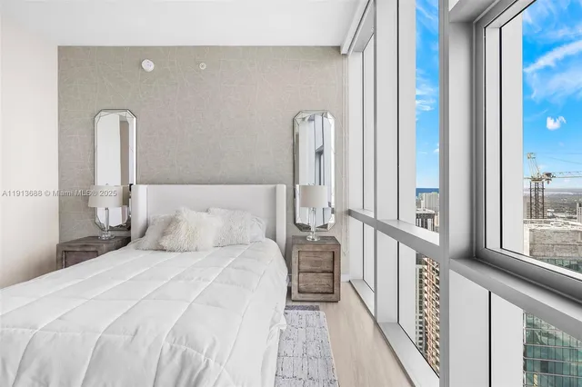 a large bedroom with a bed and wooden floor