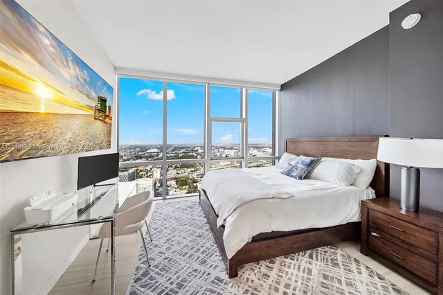 a bedroom with a bed and a large window