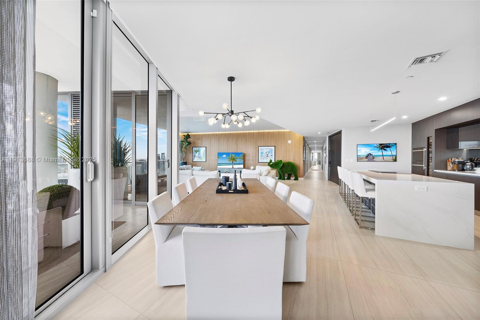 851 Northeast 1st Avenue, Unit 5312 Miami, FL 33132 - Photo 9 of 53 a kitchen with kitchen island granite countertop a refrigerator a stove a sink and a dining table with wooden floor