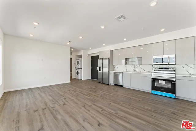 a kitchen with stainless steel appliances a stove a microwave and white cabinets