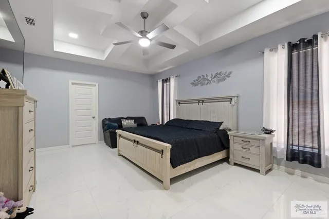 a spacious bedroom with a bed and a chandelier