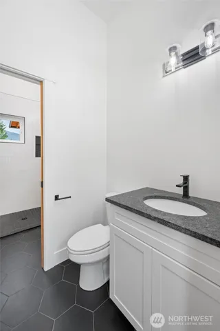 a bathroom with a granite countertop toilet and sink